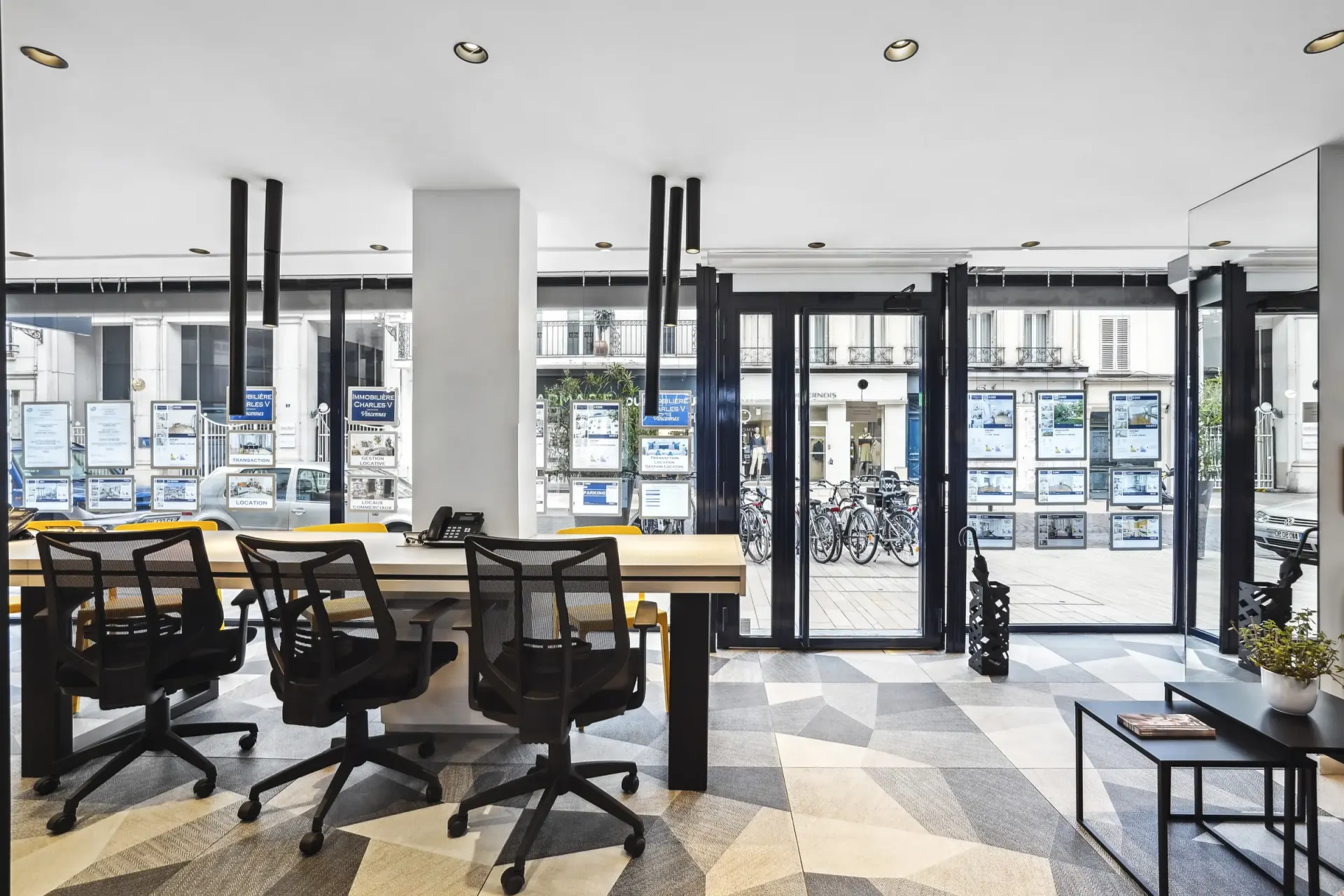 Salle de réunion de l'agence face aux vitrines d'annonces